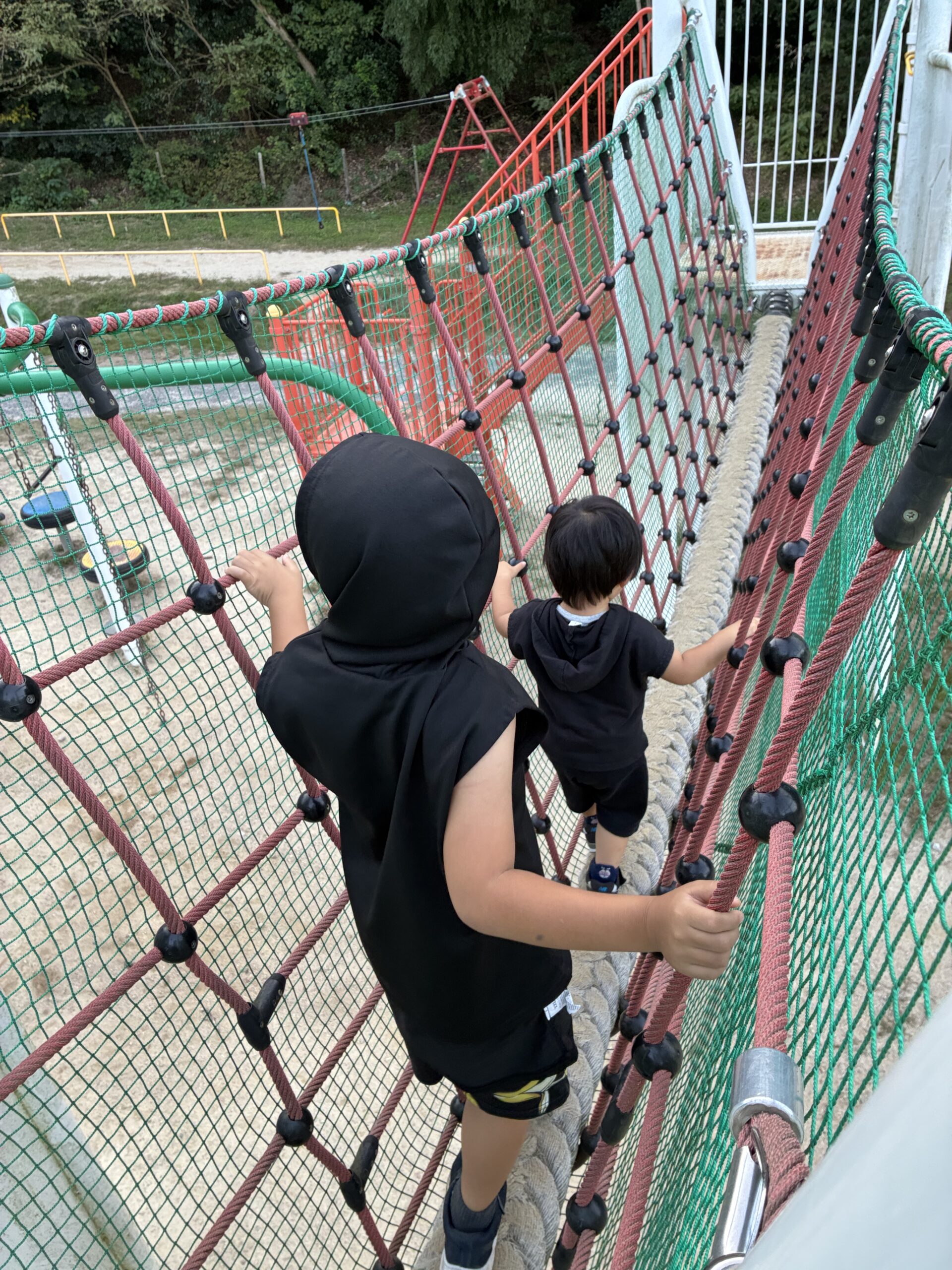 バンブー総合公園でロープの橋を渡る子ども2人の後ろ姿